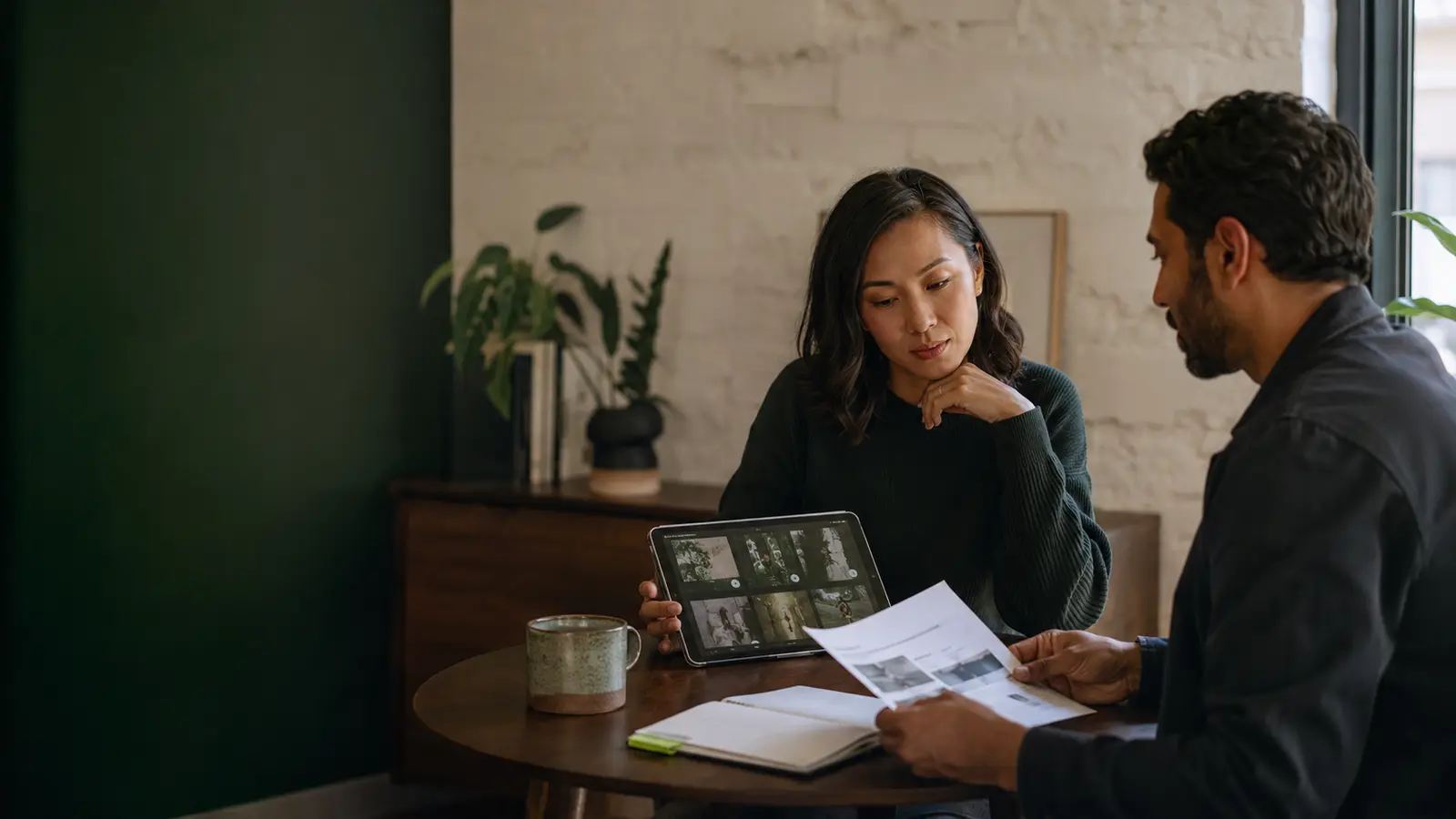 Two professionals reviewing customer interview responses and research material